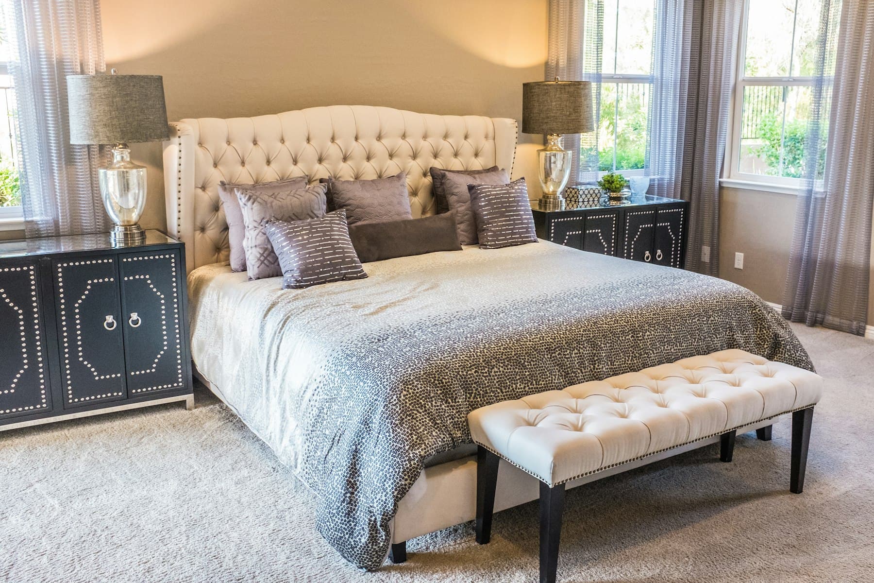 Upholstered king bed with tufted headboard and bench in a villa bedroom