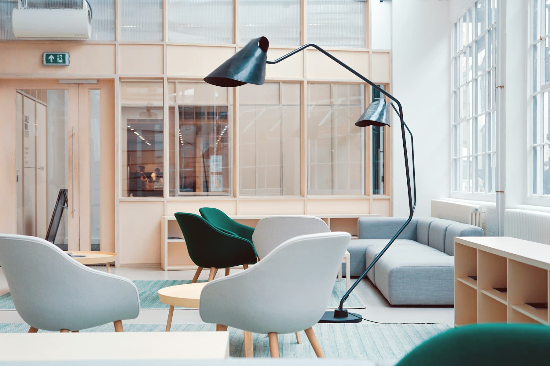 Bright open-plan office lounge with chairs, desks and shelving