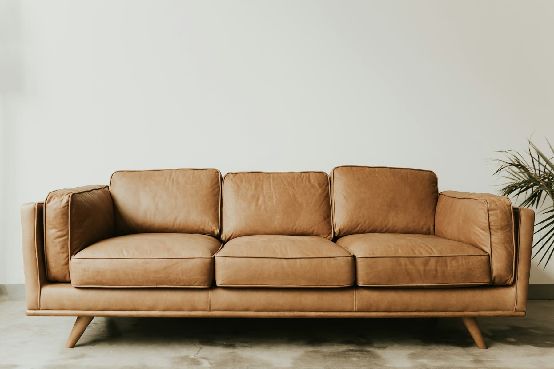 Tan leather three-seater sofa prepared for sofa removal in Dubai